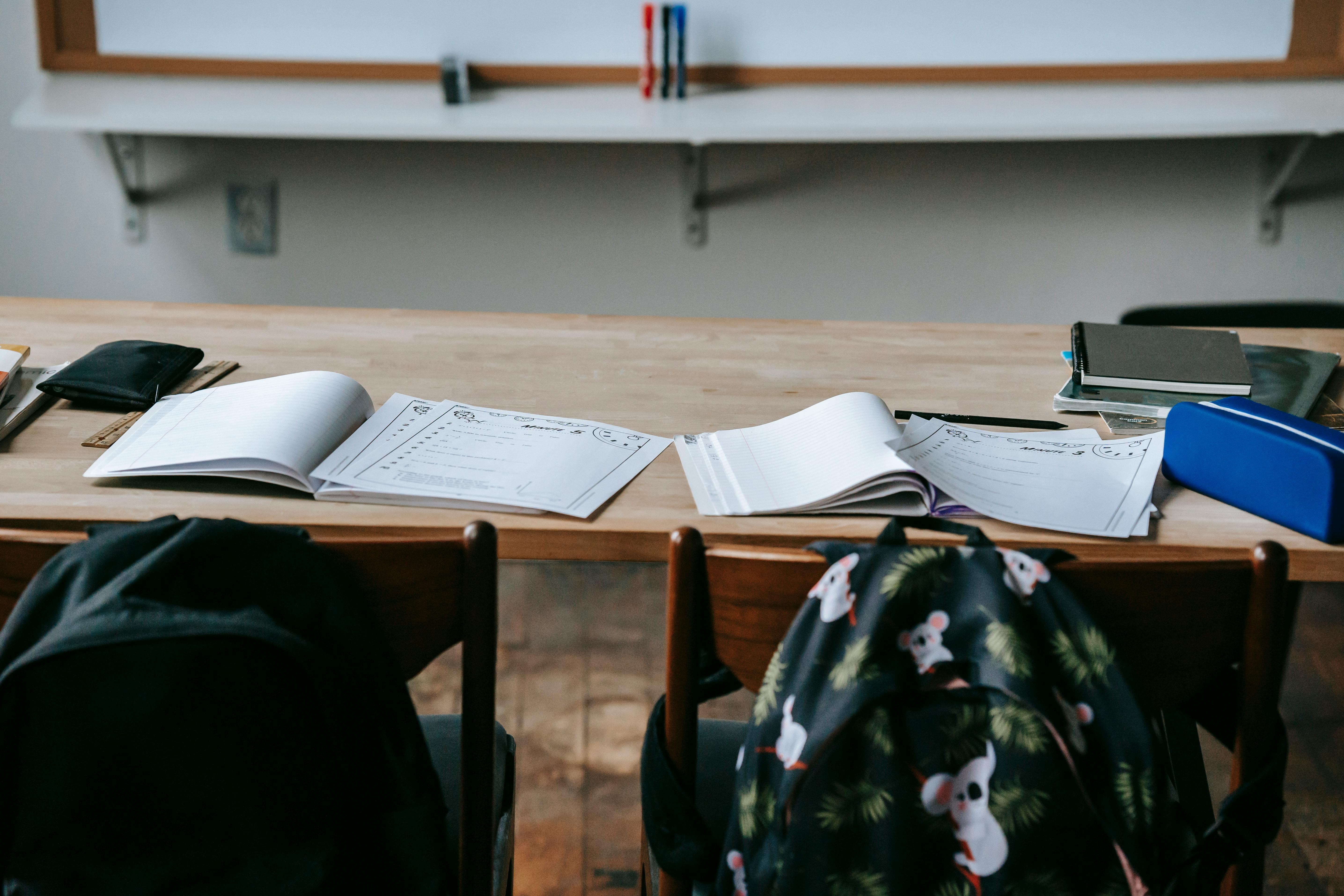 Education Analytics — classroom desk with student workbooks